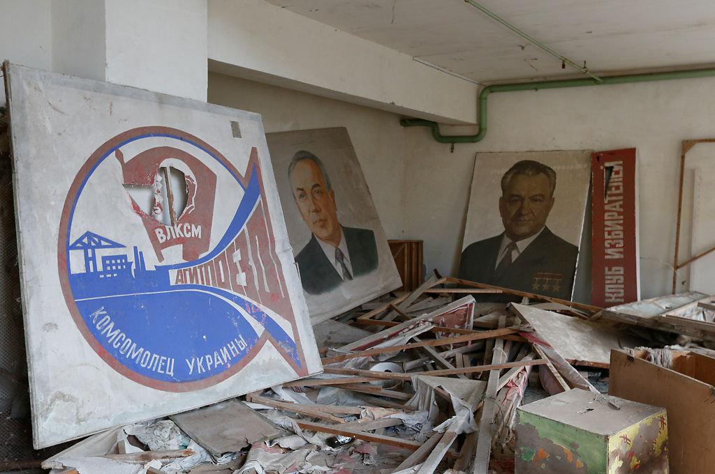 Portraits of Soviet leaders are covered by radioactive dust
